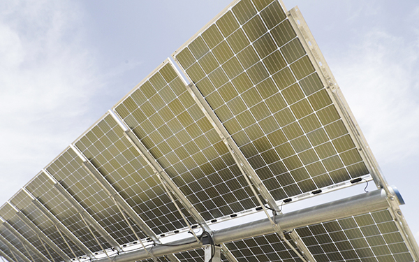 Close-up of solar panels at a Lightsource bp solar project, showing the grid pattern and metal framing under bright daylight.
